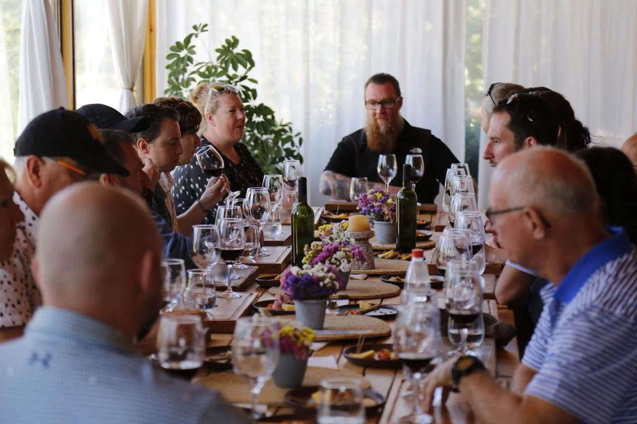 The long table set for guests, wine and flowers along its length